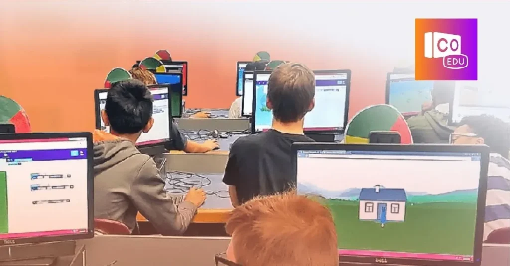 Students working on computers in a classroom, each monitor displaying different educational software with graphical interfaces, some showing simple coding tasks. There is an educational logo with 'CO EDU' written on the top right corner.