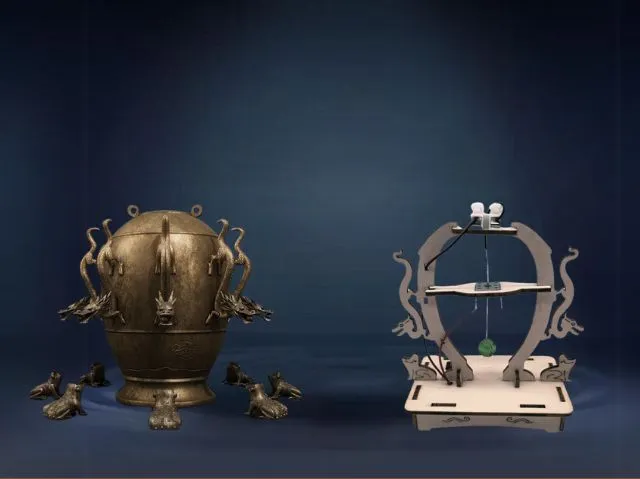 Artistic still life featuring an ancient bronze ceremonial urn with intricate animal figures, and a modern metal sculpture resembling a balance scale with animal silhouettes and a green spherical object, against a dark blue background.