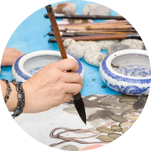 a close up picture of a hand holding a chinese paint brush