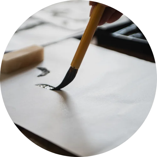a close up picture of a hand holding a chinese calligraphy brush