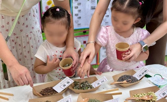 two little girls are looking at some herbs